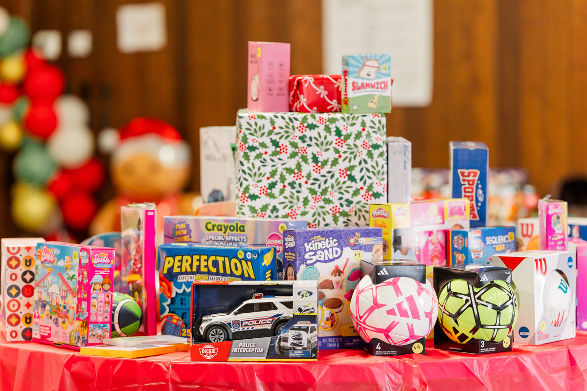 A table piled with brand-new toys, games, and sports balls at the Christmas Store